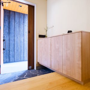 室内とは雰囲気をガラリと変え、和の趣がある玄関。床には赤松の無節材を使用。同じ赤松でも節がある材料に比べて、上品な印象になります。